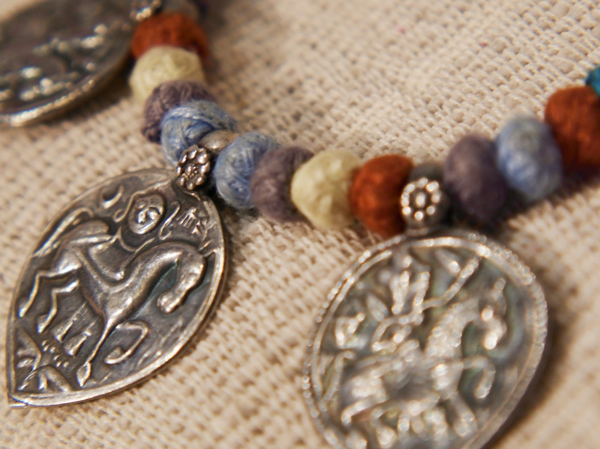 collana in cotone intrecciato con vecchi  pendaglii  raffigurantetipiche figure tribali dell'india del nord .  misure collana 44cm  pendaglio 4.5 x 3  cm  peso 51gr