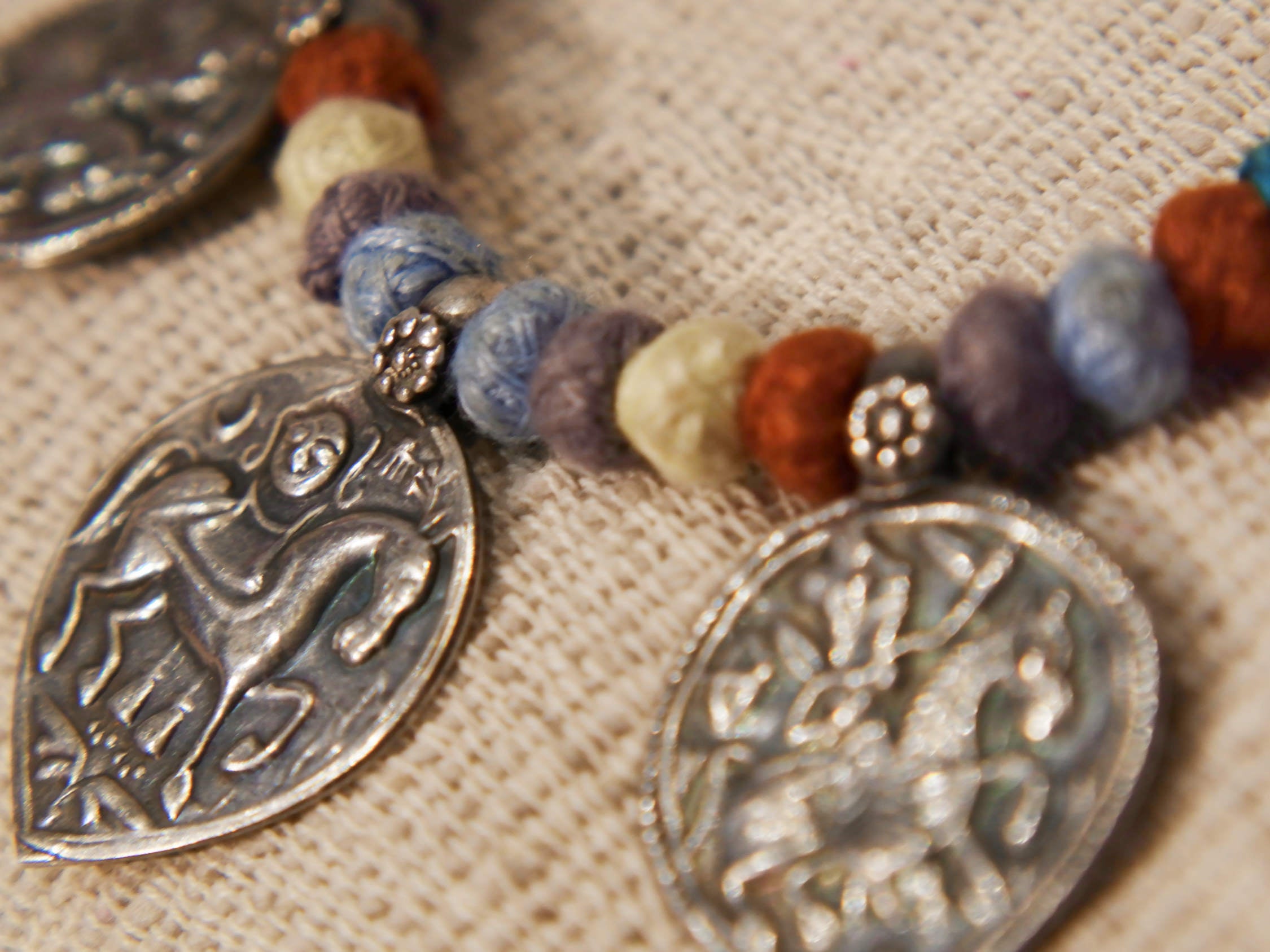 collana in cotone intrecciato con vecchi  pendaglii  raffigurantetipiche figure tribali dell'india del nord .  misure collana 44cm  pendaglio 4.5 x 3  cm  peso 51gr