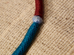 collana in cotone intrecciato con vecchi  pendaglii  raffigurantetipiche figure tribali dell'india del nord .  misure collana 44cm  pendaglio 4.5 x 3  cm  peso 51gr