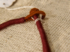 collana in cotone intrecciato con vecchi  pendaglii  raffigurantetipiche figure tribali dell'india del nord .  misure collana 44cm  pendaglio 4.5 x 3  cm  peso 51gr