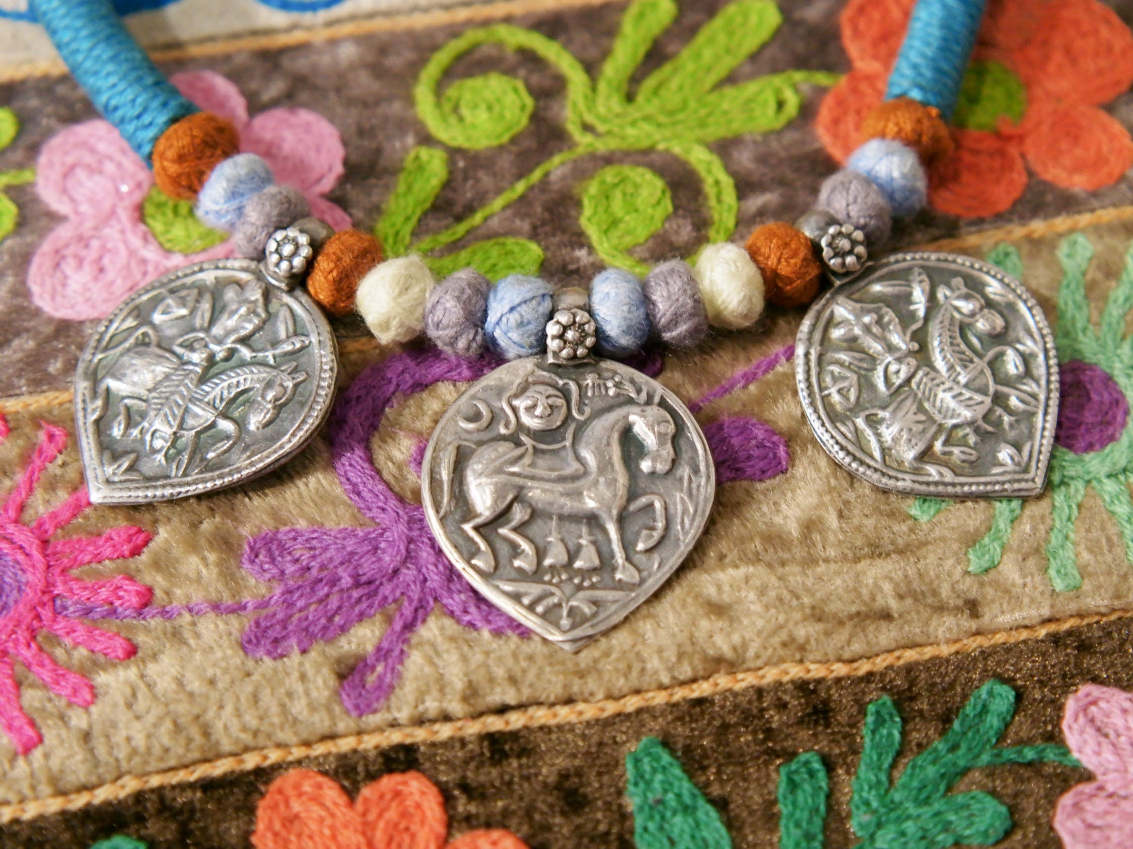 collana in cotone intrecciato con vecchi  pendaglii  raffigurantetipiche figure tribali dell'india del nord .  misure collana 44cm  pendaglio 4.5 x 3  cm  peso 51gr