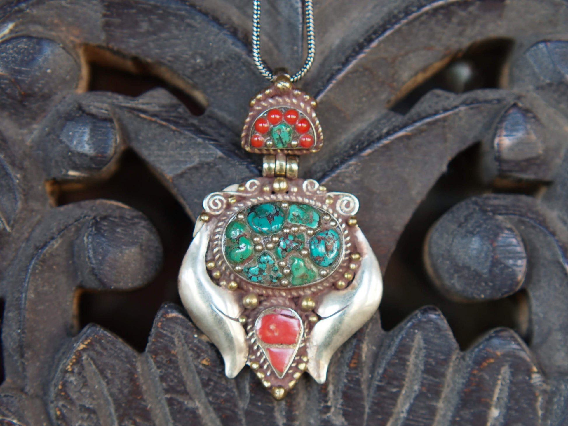 pendaglio tibetano / nepalese in argento con turchesi e corallo  pezzo unico lavorato artigianalmente tutto originale ed autentico .  cesellato ed inciso con i simboli del buon auspicio tibetano .  peso 24 gr  dimensioni 6x4x1 cm
