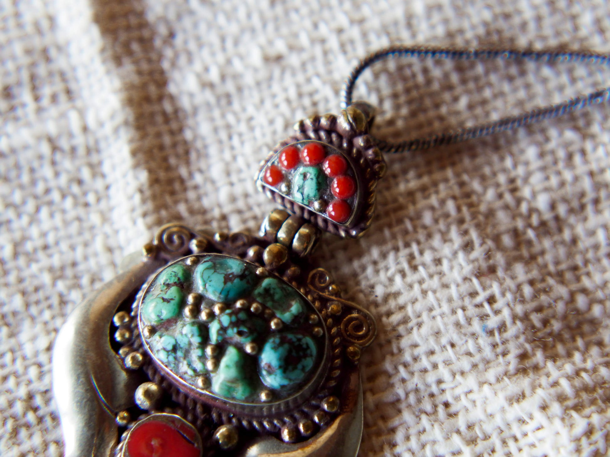 pendaglio tibetano / nepalese in argento con turchesi e corallo  pezzo unico lavorato artigianalmente tutto originale ed autentico .  cesellato ed inciso con i simboli del buon auspicio tibetano .  peso 24 gr  dimensioni 6x4x1 cm