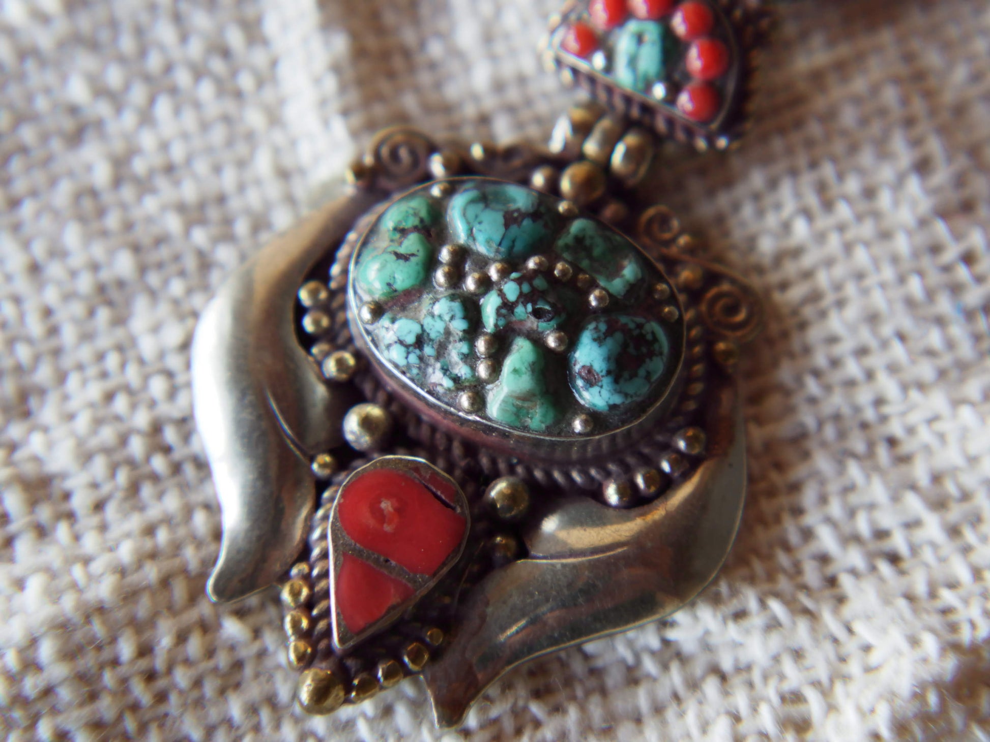 pendaglio tibetano / nepalese in argento con turchesi e corallo  pezzo unico lavorato artigianalmente tutto originale ed autentico .  cesellato ed inciso con i simboli del buon auspicio tibetano .  peso 24 gr  dimensioni 6x4x1 cm