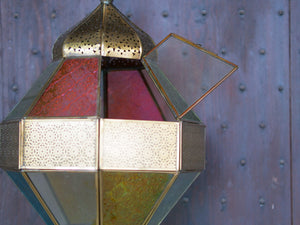 Lanterna indiana in metallo lavorata artigianalmente, finemente decorata a traforo, con vetro multicolor e trasparente.  Disponibile anche nella versione con solo vetro trasparente. Con piccolo portacandele interno e gancio per appendere .    dimensioni diametro 25  h55  per info ed ulteriori foto info@etniko.it facebook / instagram / pinterest : etnikobycrosato 0039 3338778241