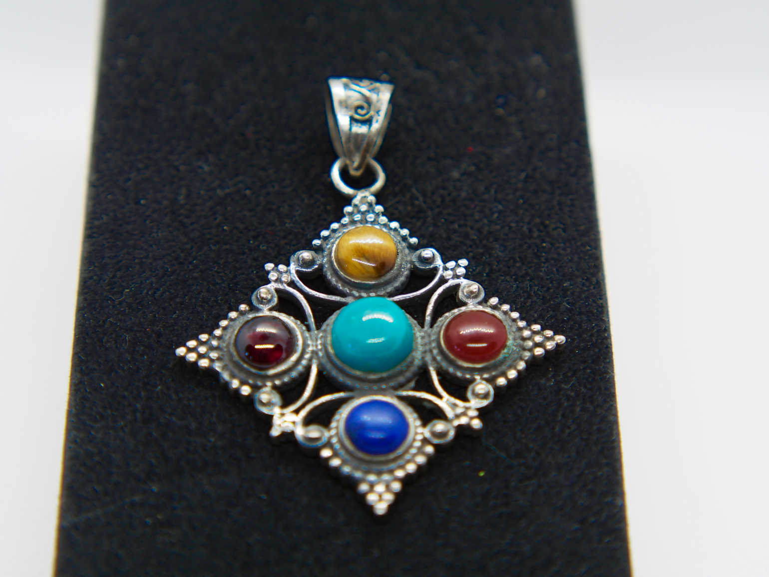 pendaglio tibetano / nepalese in argento 800 con turchese , lapislazzulo ,corniola , granato e occhio di tigre  pezzo unico lavorato artigianalmente tutto originale ed autentico .   peso 15gr  dimensioni 4,3x4,3 cm