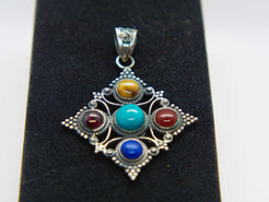 pendaglio tibetano / nepalese in argento 800 con turchese , lapislazzulo ,corniola , granato e occhio di tigre  pezzo unico lavorato artigianalmente tutto originale ed autentico .   peso 15gr  dimensioni 4,3x4,3 cm