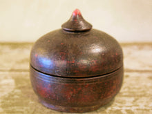 Carica l&#39;immagine nel visualizzatore di Gallery, Box Tikka Indiano antico in legno di teak ricavato da un unico tronco di legno incavato e laccato, databile primi anni del 900, porta molto bene l&#39;usura e la patina del tempo . Pezzo unico per contenere il Tikka, polvere rossa utilizzata essenzialmente per cerimonie di origine Induista dove si segna la fronte con una striscia rossa . dimesnioni diametro 13 h14 cm.    per ulteriori info o foto contattare via mail info@etniko.it watshapp 0039 3338778241 instagram , facebook, etsy : etnikobycrosato