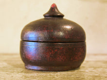 Carica l&#39;immagine nel visualizzatore di Gallery, Box Tikka Indiano antico in legno di teak ricavato da un unico tronco di legno incavato e laccato, databile primi anni del 900, porta molto bene l&#39;usura e la patina del tempo . Pezzo unico per contenere il Tikka, polvere rossa utilizzata essenzialmente per cerimonie di origine Induista dove si segna la fronte con una striscia rossa . dimesnioni diametro 13 h14 cm.    per ulteriori info o foto contattare via mail info@etniko.it watshapp 0039 3338778241 instagram , facebook, etsy : etnikobycrosato