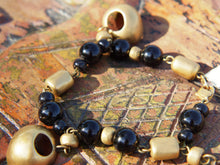 Carica l&#39;immagine nel visualizzatore di Gallery, bracciale in onice e pendagli in argento placcato oro 24 kt, stile maya azteco, classici simboli della cultura sud americana. pietre di prima qualità, colore omogeneo senza intrusioni. Pezzo unico. Disponibile anche collana e orecchini in abbinato.  lunghezza 19 cm, peso 36 gr 