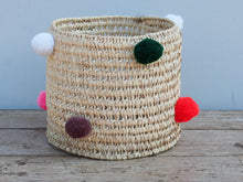 Carica l&#39;immagine nel visualizzatore di Gallery, Cesto in paglia con pom pom mix color, realizzata a mano. provenienza marocco. pezzo unico. Dimensioni diametro 26 h26cm  per info ed ulteriori foto info@etniko.it facebook / instagram / pinterest : etnikobycrosato 0039 3338778241