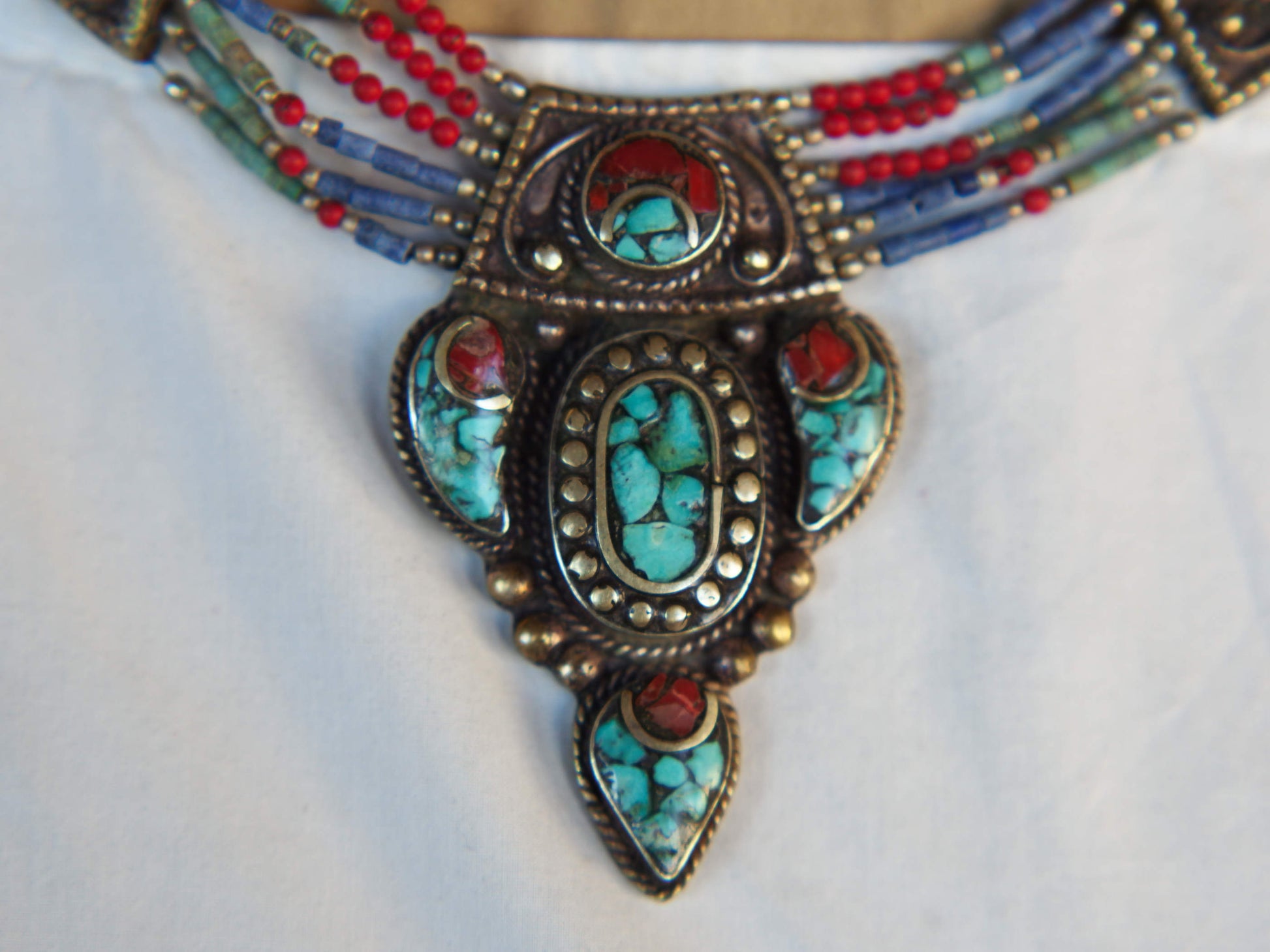 collana nepalese / tibetana multifilo con corallo, turchese, lapis e argento. no pasta ma pietre vere non tinte o modificate nel colore, qualità top. assemblata artigianalmente, pezzo unico.  lunghezza totale collana 43 cm, pendaglio 3.5x5.5cm, peso 74 gr
