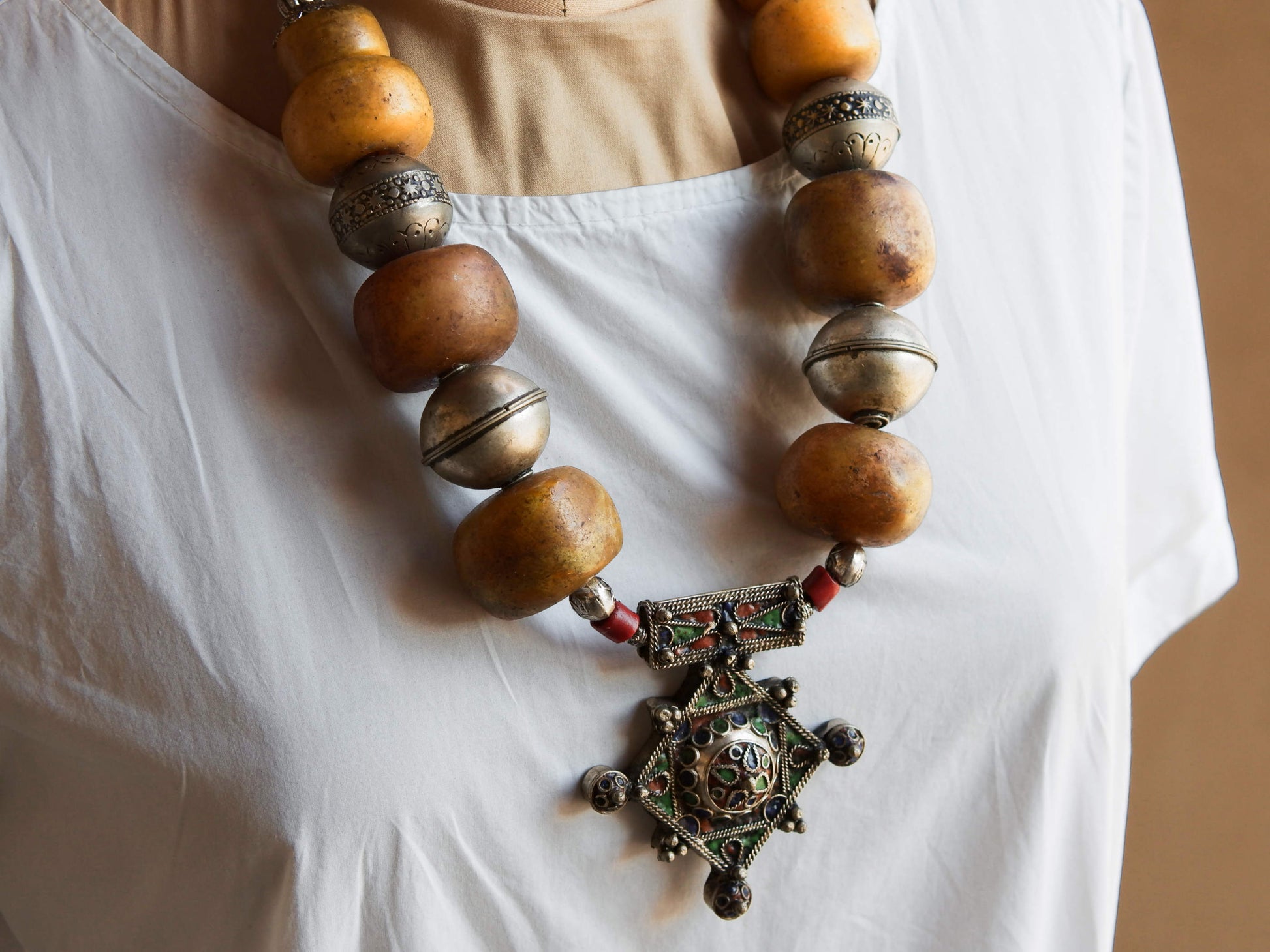 Collana tribale Amazigh, Berbera.  Fatta a mano da artigiani berberi tradizionali con perline in pietre, corna, resine plastiche e vegetali naturali , alcuni pezzi in argentone. pezzo unico e di difficile reperibilità , elementi databili anni 60/70 . Il diametro massimo della collana è di 3,5 cm. pendaglio 8 x 7 x 1 cm 