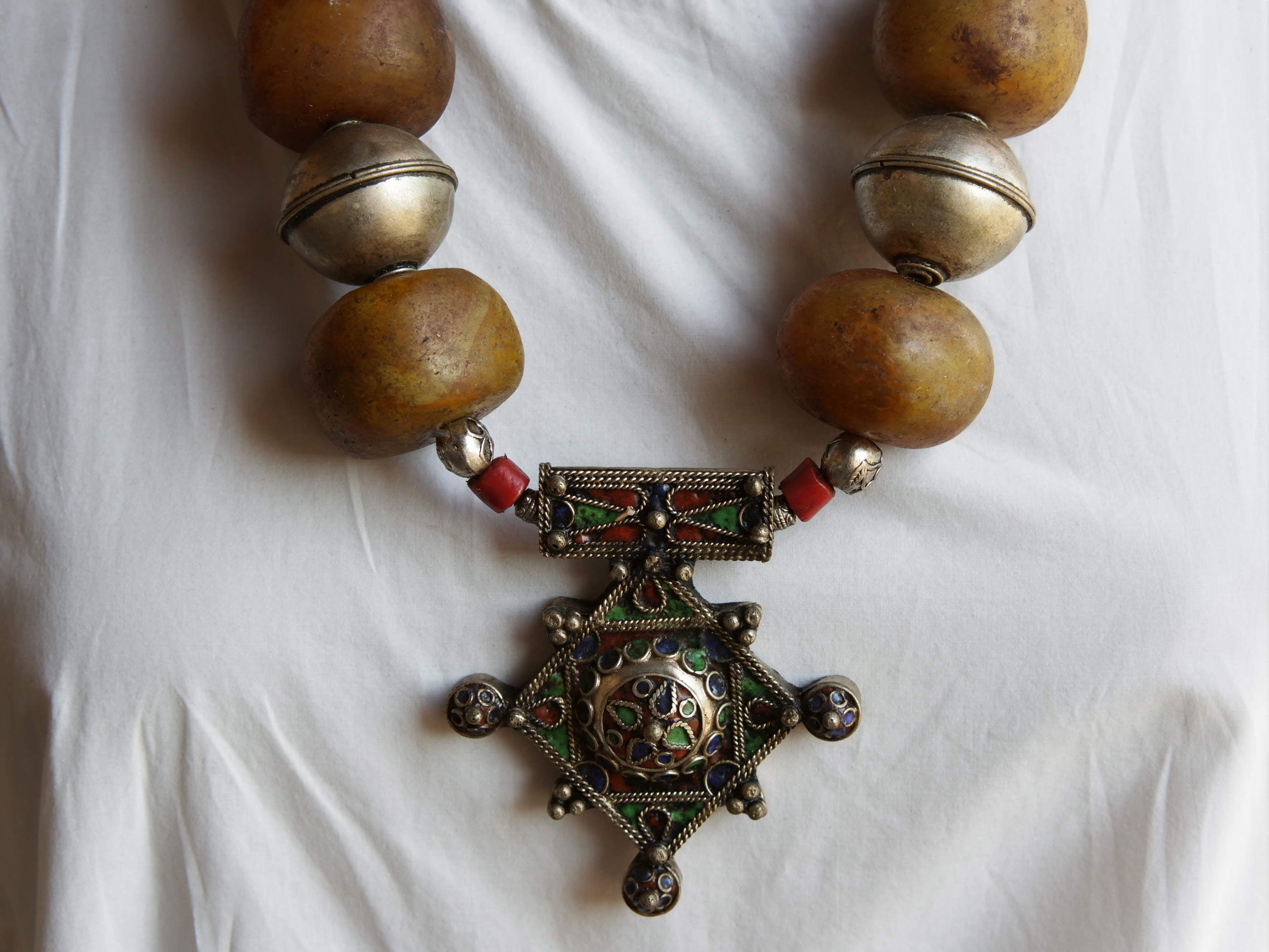 Collana tribale Amazigh, Berbera.  Fatta a mano da artigiani berberi tradizionali con perline in pietre, corna, resine plastiche e vegetali naturali , alcuni pezzi in argentone. pezzo unico e di difficile reperibilità , elementi databili anni 60/70 . Il diametro massimo della collana è di 3,5 cm. pendaglio 8 x 7 x 1 cm 
