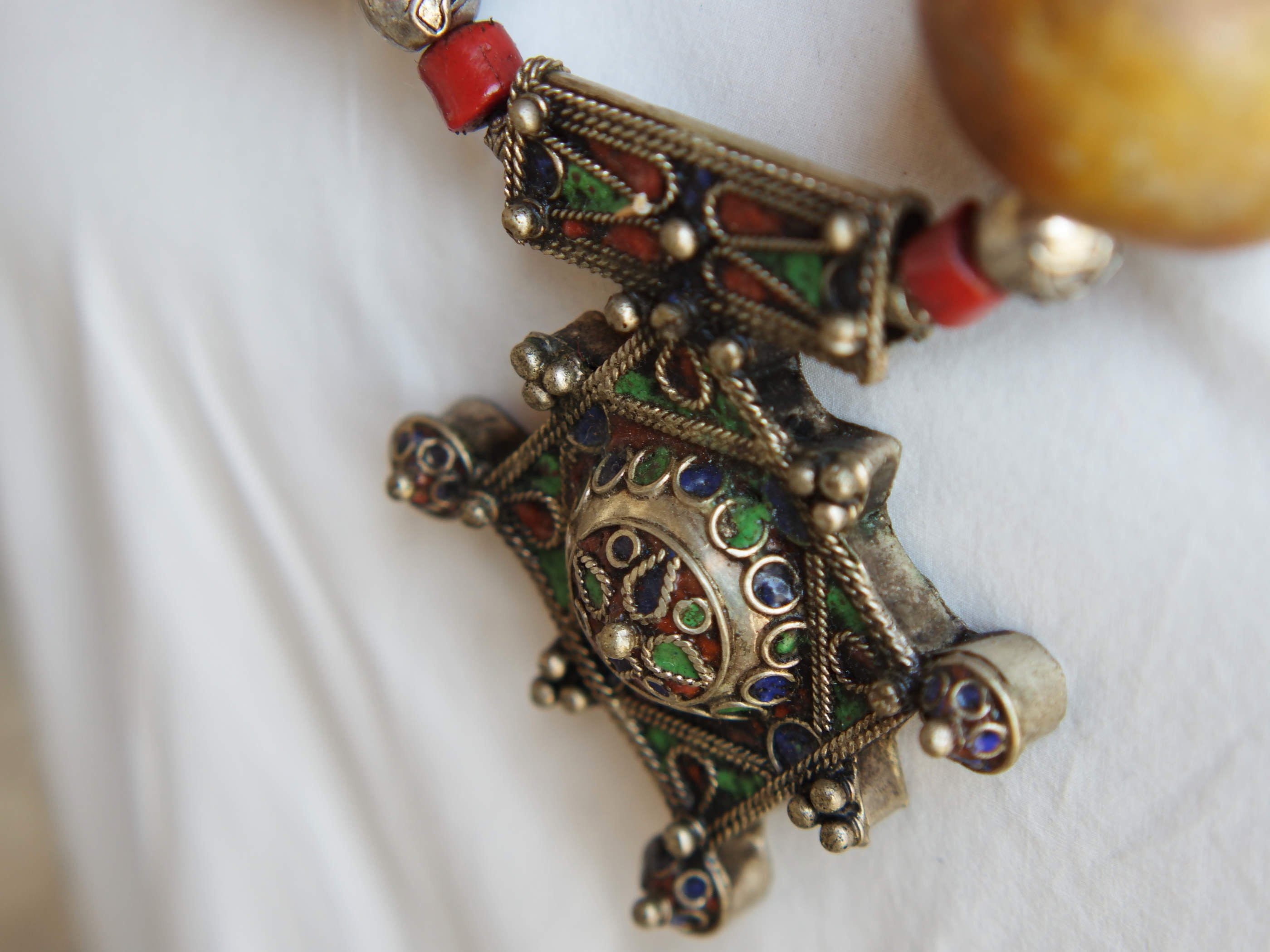 Collana tribale Amazigh, Berbera.  Fatta a mano da artigiani berberi tradizionali con perline in pietre, corna, resine plastiche e vegetali naturali , alcuni pezzi in argentone. pezzo unico e di difficile reperibilità , elementi databili anni 60/70 . Il diametro massimo della collana è di 3,5 cm. pendaglio 8 x 7 x 1 cm 