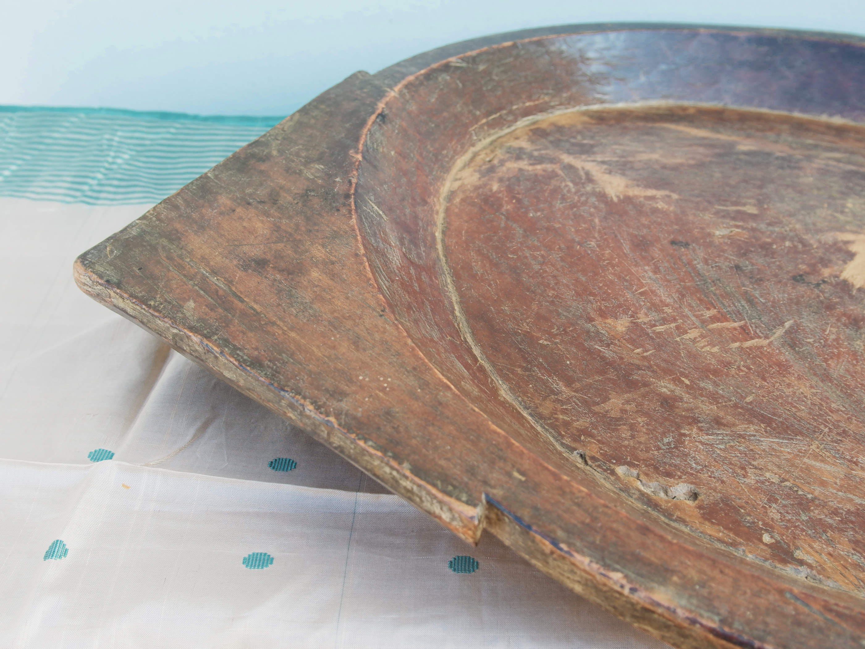 piatto in legno con manico ricavato da un unico tronco di legno. usato in principio come piatto , setaccio per esiccare i cereali . tronco unico di teak massello databile inizio / metà 900 .  dimensioni 75x54xh6cm.   disponibili vari modelli , contattare per info ed ulteriori foto info@etniko.it 0039 3338778241 fb/ig : etnikobycrosato