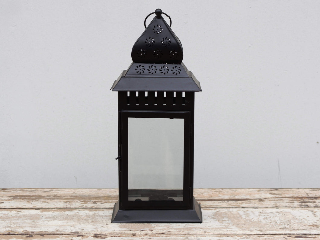 Lanterna indiana in metallo lavorata artigianalmente, nella parte superiore finemente decorata a traforo, nera, con vetro trasparente. Disponibile anche nella versione con vetro giallo. Con piccolo portacandele interno e gancio per appendere .  prezzo originale euro 50 scontato euro 38  dimensioni 18x13 h45  per info ed ulteriori foto info@etniko.it facebook / instagram / pinterest : etnikobycrosato 0039 3338778241