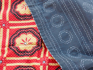 Tessuto print block ricamato in cotone doppio strato double face con specchietti. I disegni geometrici sono su sfondo rosso, nero e panna, mentre il retro e nero con ricamo bianco. Può essere impiegato come copridivano, copriletto o tessuto da appendere a parete. Dimensioni 210x260cm