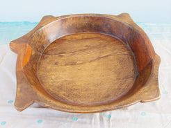 piatto in legno con manico ricavato da un unico tronco di legno. usato in principio come piatto , setaccio per esiccare i cereali . tronco unico di teak massello databile inizio / metà 900 .  dimensioni 35x38xh7cm.   disponibili vari modelli , contattare per info ed ulteriori foto info@etniko.it 0039 3338778241 fb/ig : etnikobycrosato