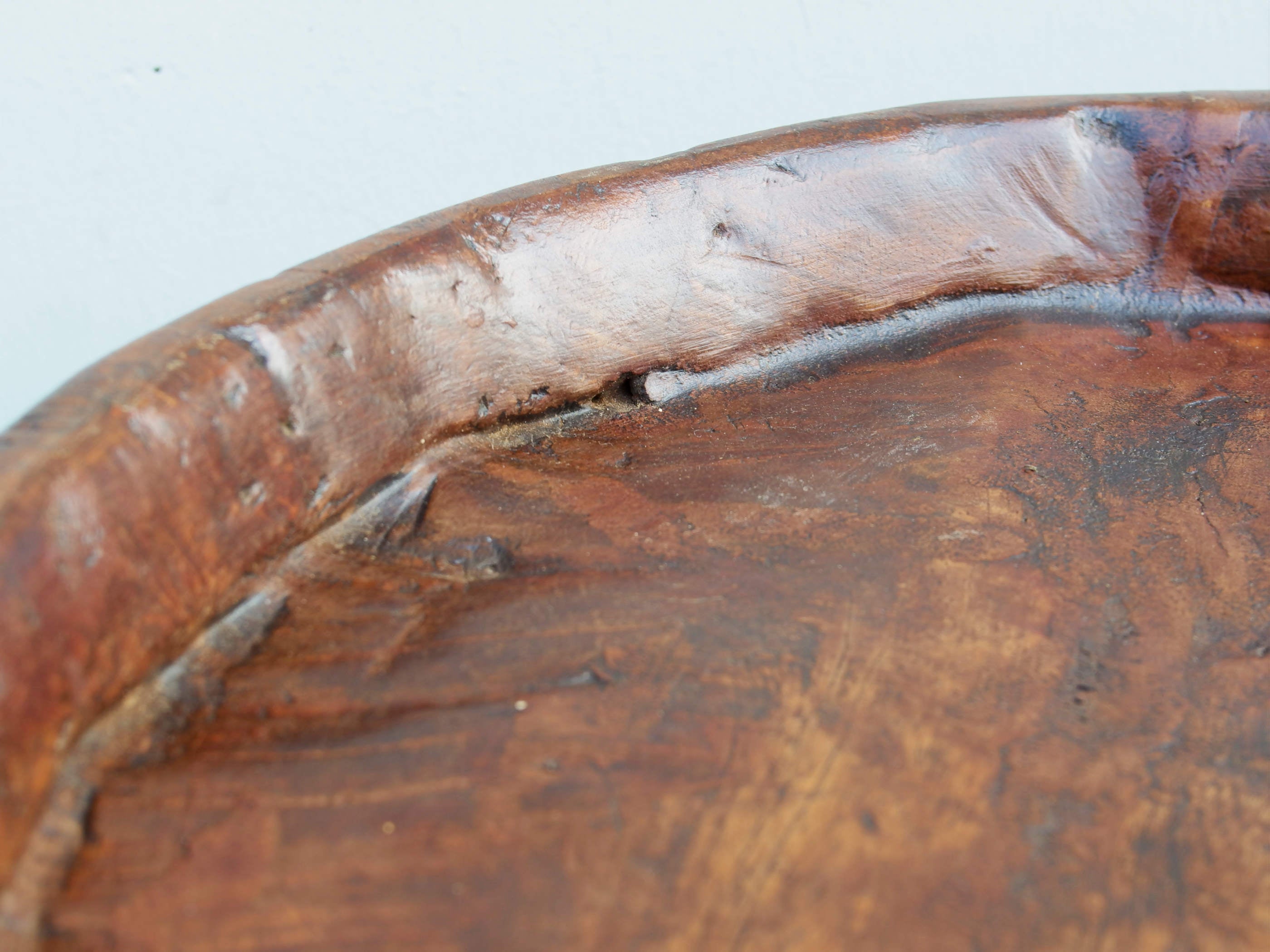 piatto in legno con manico ricavato da un unico tronco di legno.  usato in principio come piatto , setaccio per esiccare i cereali .  tronco unico di teak massello databile inizio / metà 900 .  dimensioni 40x54xh6cm.    disponibili vari modelli , contattare per info ed ulteriori foto info@etniko.it 0039 3338778241 fb/ig : etnikobycrosato