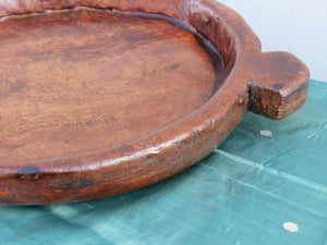 piatto in legno con manico ricavato da un unico tronco di legno.  usato in principio come piatto , setaccio per esiccare i cereali .  tronco unico di teak massello databile inizio / metà 900 .  dimensioni 40x54xh6cm.    disponibili vari modelli , contattare per info ed ulteriori foto info@etniko.it 0039 3338778241 fb/ig : etnikobycrosato