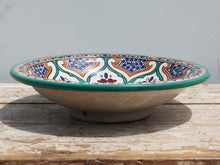 Carica l&#39;immagine nel visualizzatore di Gallery, Piatto decorato Marocco dipinto in terracotta di fes. La Tradizionale Terracotta Di Fes é Impastata, Decorata, Cotta, Smaltata E Nuovamente Cotta Nel Forno A Legna (Non Nel Forno A Gas Che Rende Lo Smalto Omogeneo E Senza L&#39;Effetto Delle Crepe). Decorato artigianlamente con i classici motivi berberi marocchini . Pezzo Unico. fori sul retro per poterlo appendere . base per appoggio .  Dimensioni Diametro 35 h9cm