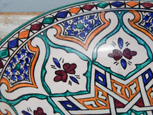 Carica l&#39;immagine nel visualizzatore di Gallery, Piatto decorato Marocco dipinto in terracotta di fes. La Tradizionale Terracotta Di Fes é Impastata, Decorata, Cotta, Smaltata E Nuovamente Cotta Nel Forno A Legna (Non Nel Forno A Gas Che Rende Lo Smalto Omogeneo E Senza L&#39;Effetto Delle Crepe). Decorato artigianlamente con i classici motivi berberi marocchini . Pezzo Unico. fori sul retro per poterlo appendere . base per appoggio .  Dimensioni Diametro 35 h9cm