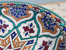 Carica l&#39;immagine nel visualizzatore di Gallery, Piatto decorato Marocco dipinto in terracotta di fes. La Tradizionale Terracotta Di Fes é Impastata, Decorata, Cotta, Smaltata E Nuovamente Cotta Nel Forno A Legna (Non Nel Forno A Gas Che Rende Lo Smalto Omogeneo E Senza L&#39;Effetto Delle Crepe). Decorato artigianlamente con i classici motivi berberi marocchini . Pezzo Unico. fori sul retro per poterlo appendere . base per appoggio .  Dimensioni Diametro 35 h9cm
