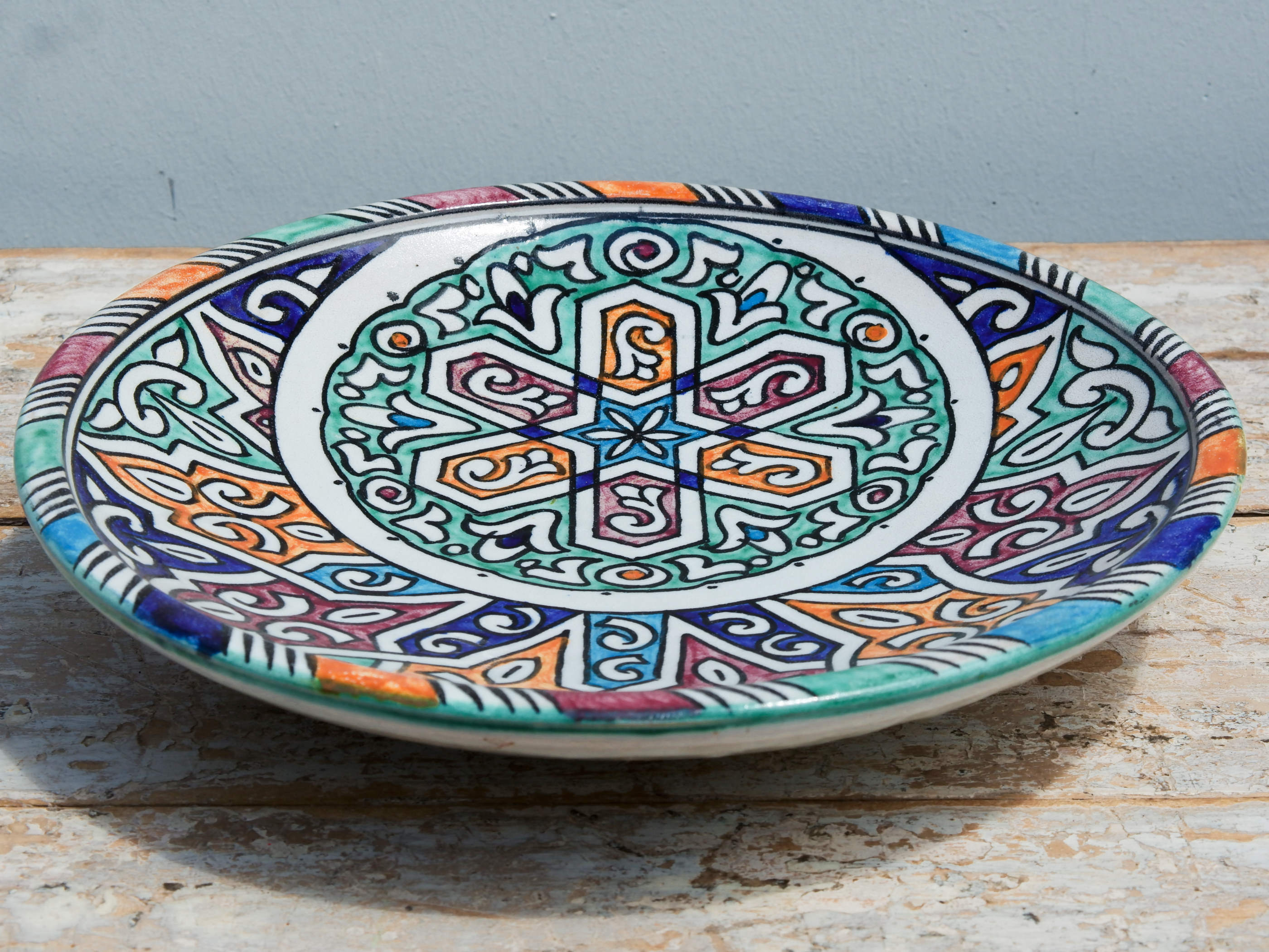 Piatto decorato Marocco dipinto in terracotta di fes. La Tradizionale Terracotta Di Fes é Impastata, Decorata, Cotta, Smaltata E Nuovamente Cotta Nel Forno A Legna (Non Nel Forno A Gas Che Rende Lo Smalto Omogeneo E Senza L'Effetto Delle Crepe). Decorato artigianlamente con i classici motivi berberi marocchini . Pezzo Unico. fori sul retro per poterlo appendere . base per appoggio .  Dimensioni Diametro 31 h6cm