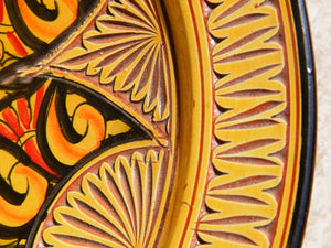 Piatto marocchino decorato e dipinto in terracotta di Fes. La tradizionale terracotta di Fes é Impastata, decorata, cotta, smaltata e nuovamente cotta nel forno a legna (non nel forno a gas che rende lo smalto omogeneo e senza l'effetto delle crepe). Decorato artigianlamente con i classici motivi berberi marocchini. Inserti in metallo inciso e pelle decorata. Pezzo Unico. Fori sul retro per poterlo appendere. Base per appoggio .  Dimensioni Diametro 35 h 8 cm