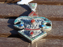 Carica l&#39;immagine nel visualizzatore di Gallery, pendaglio tibetano / nepalese in argento con turchesi, lapislazzulo e corallo.  pezzo unico lavorato artigianalmente tutto originale ed autentico.  cesellato ed inciso con i simboli del buon auspicio tibetano.  peso 45 gr  dimensioni 9 x 6  h1 cm  info@etniko.it www.etniko.it 0039 3338778241  fb/ig/ebay:etnikobycrosato