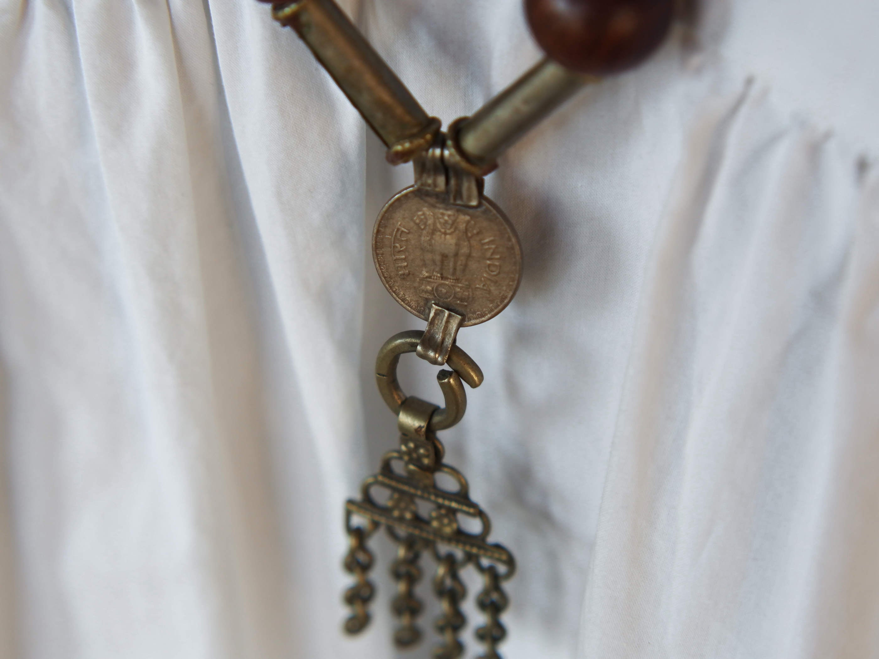 Collana in lega di argento e legno finemente lavorata tipica del rajastahn tribale indiano. COMPOSTA DA ELEMENTI RECUPERATI DA VECCHIE COLLANE , ORECCHINI , PENDAGLI ... pendaglio finale 2x8cm montato su filo di cotone, elementi a tubo e monete.  Collana lunghezza 84 cm, peso 42 gr