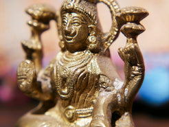 Primo piano dei dettagli del volto e dell'acconciatura rituale della divinità.