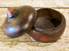 Carica l&#39;immagine nel visualizzatore di Gallery, Box Tikka Indiano antico in legno di teak ricavato da un unico tronco di legno incavato e laccato, databile primi anni del 900, porta molto bene l&#39;usura e la patina del tempo . Pezzo unico per contenere il Tikka, polvere rossa utilizzata essenzialmente per cerimonie di origine Induista dove si segna la fronte con una striscia rossa . dimesnioni diametro 11 h12 cm.    per ulteriori info o foto contattare via mail info@etniko.it watshapp 0039 3338778241 instagram , facebook, etsy : etnikobycrosato