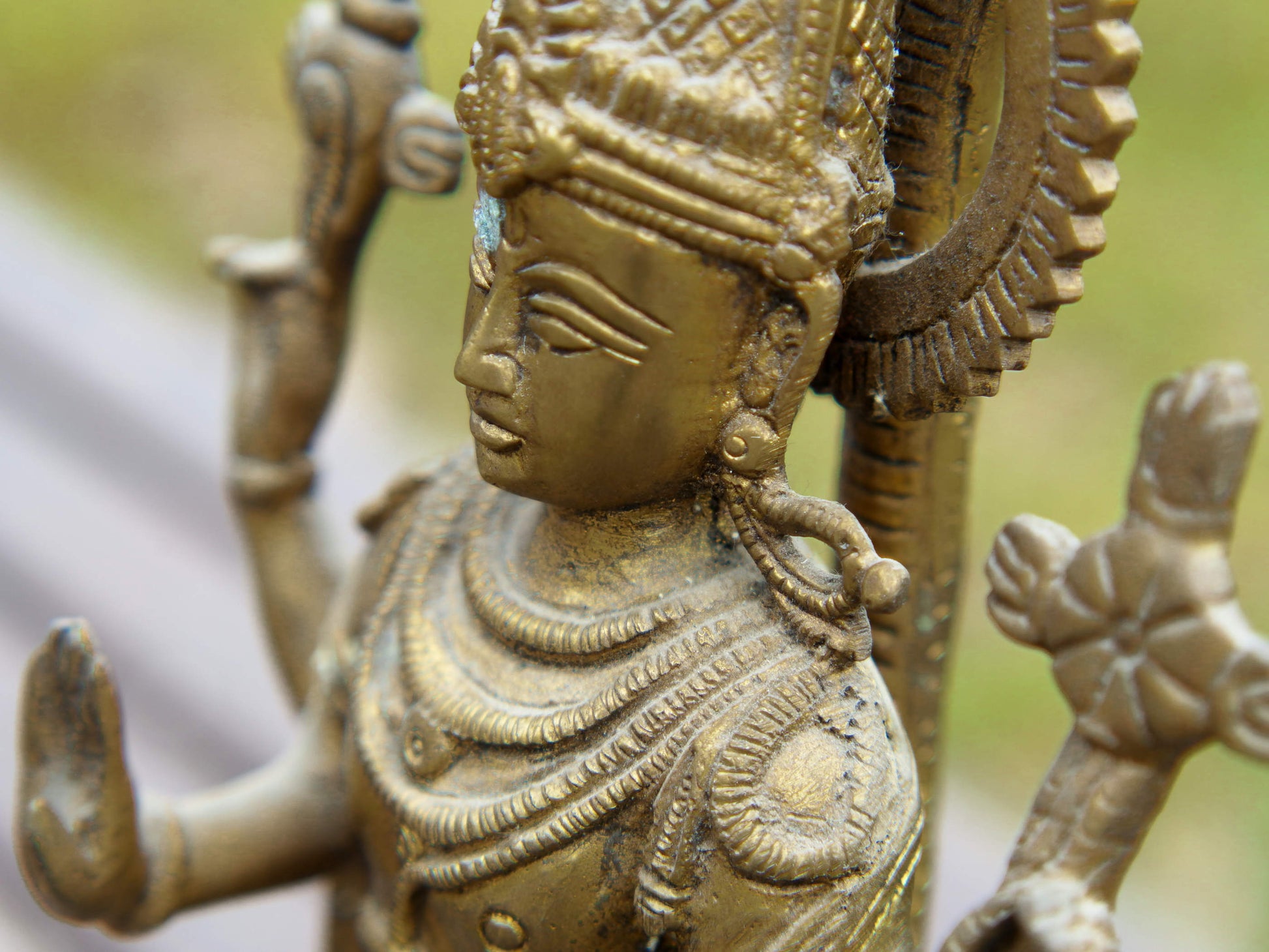 particolare della lavorazione della statuetta indiana in lega di metalli raffigurante vishnu 